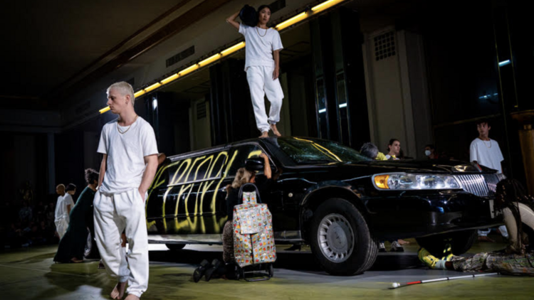 Dancers dressed in white climbing on a limousine 