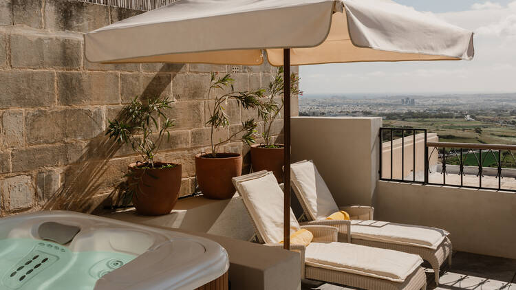 Outdoor area with hot tub and sun loungers at Xara Palace