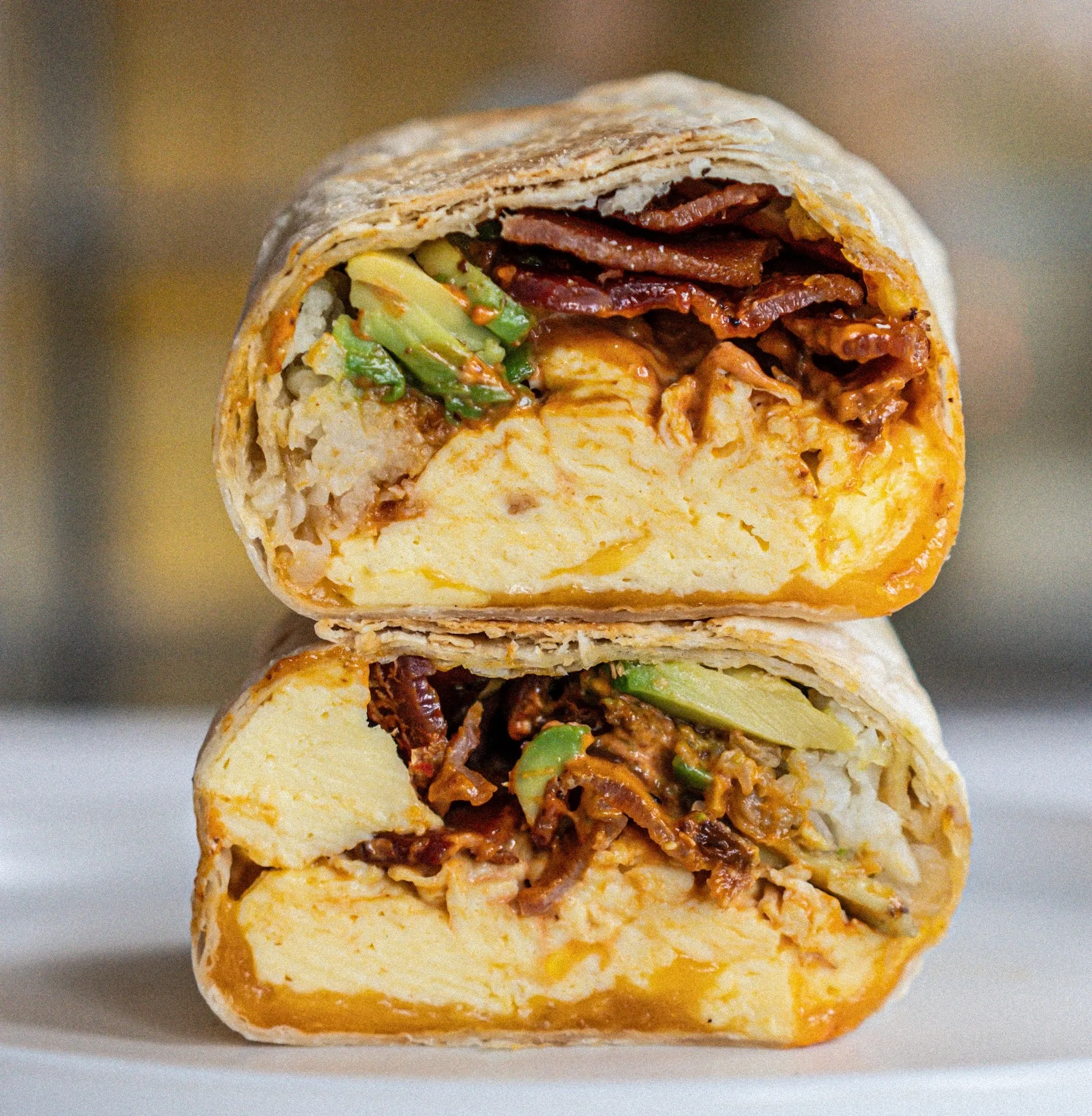 Drugstore's Bacon Breakfast Burrito cut into two halves on stacked on each other