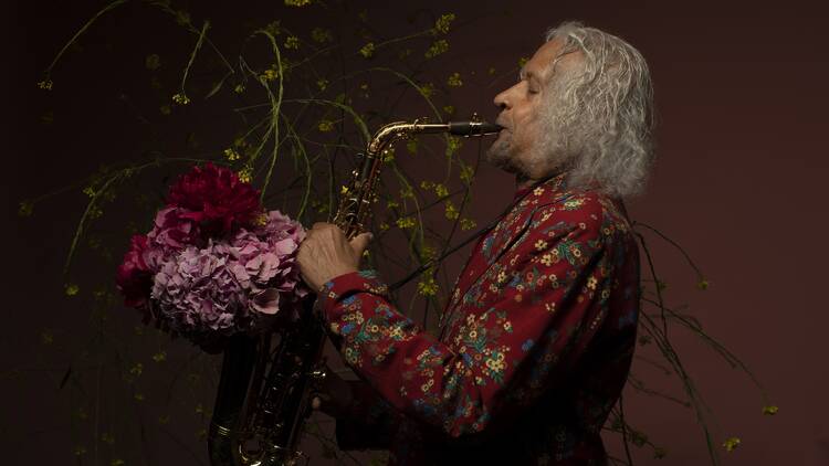 Musician Gary Bartz playing a saxophone with flowers coming out.