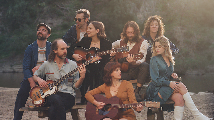 A group of musicians sitting on a park bench.