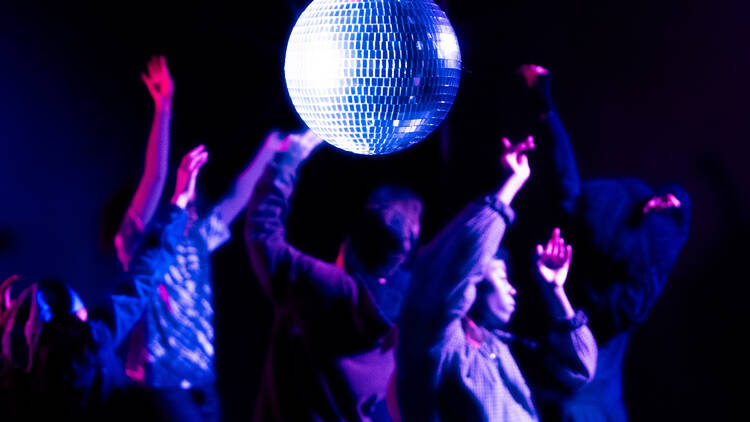 People dancing under a disco ball.