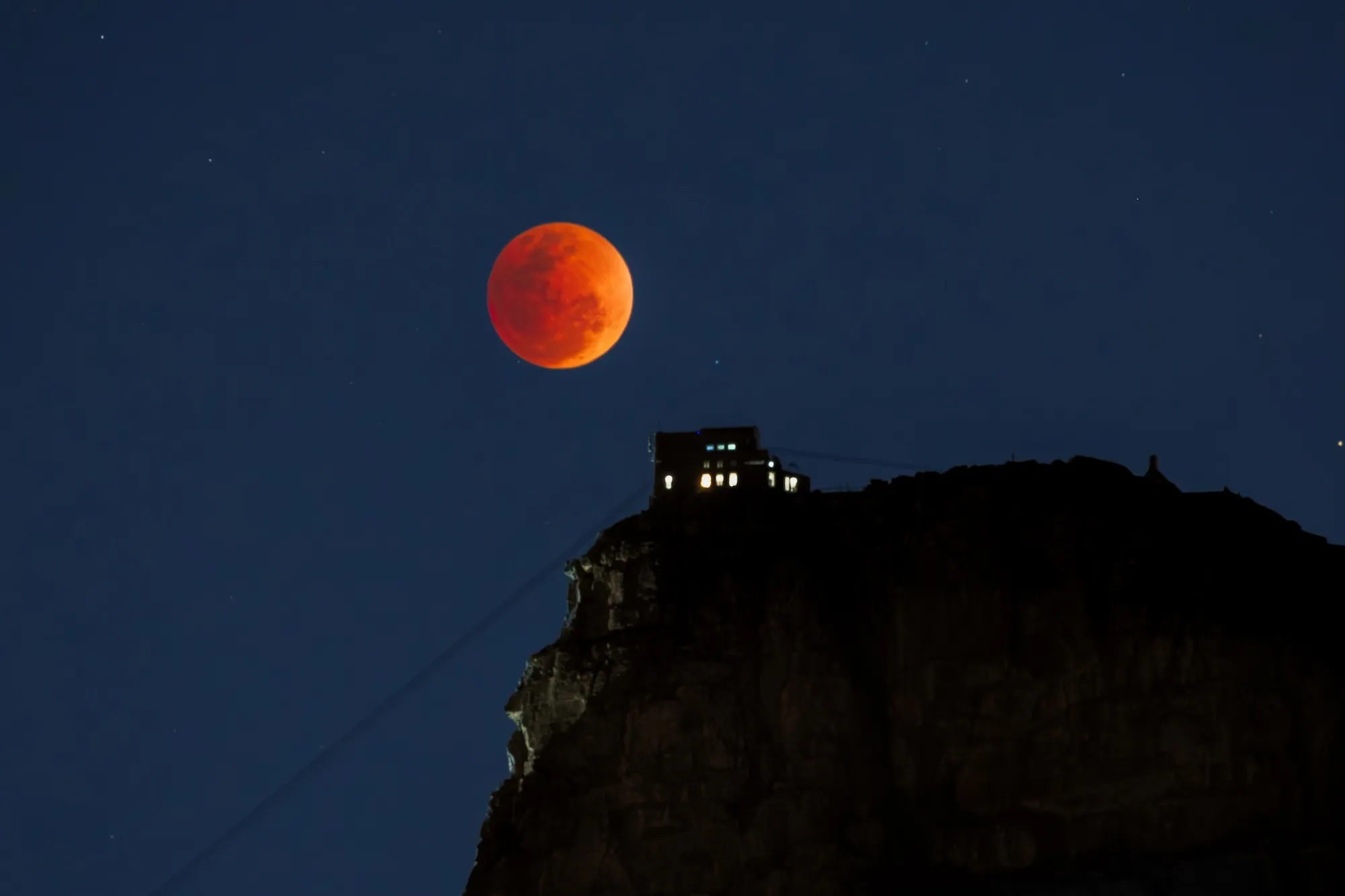 The Blood Moon peaking just above Table Mountain Aerial Cableway.