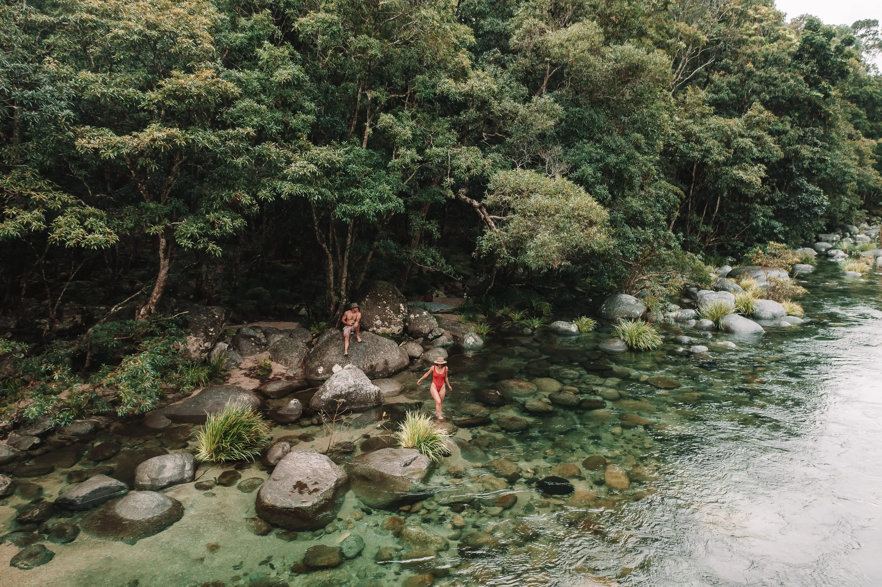 Couple walking on the boulders at Mossman River