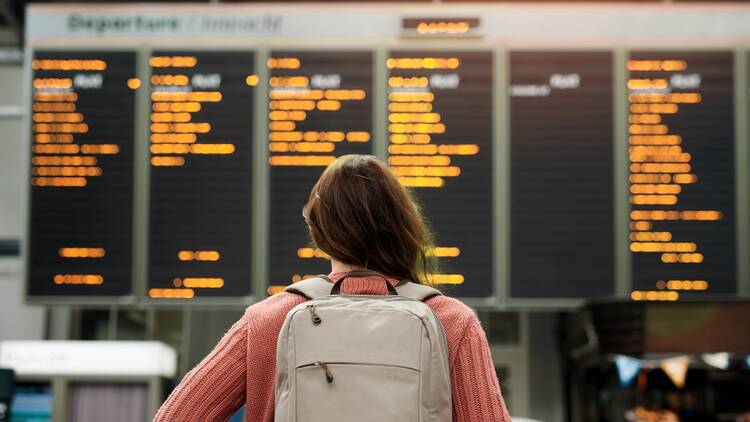 Traveler looking at airport departure board