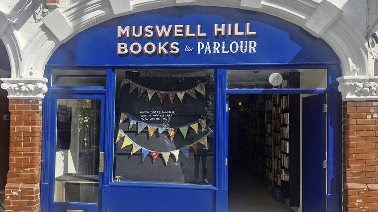 Blue exterior of the bookshop with signage and festive banners. 