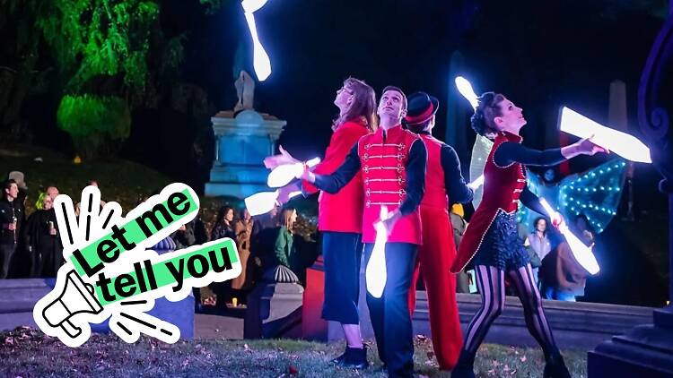 Jugglers throw illuminated pins into the air during an event.