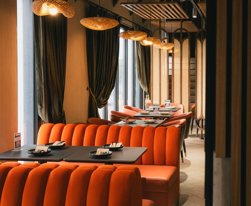 Uday Restaurant's plush orange booths and wicker pendant lighting.