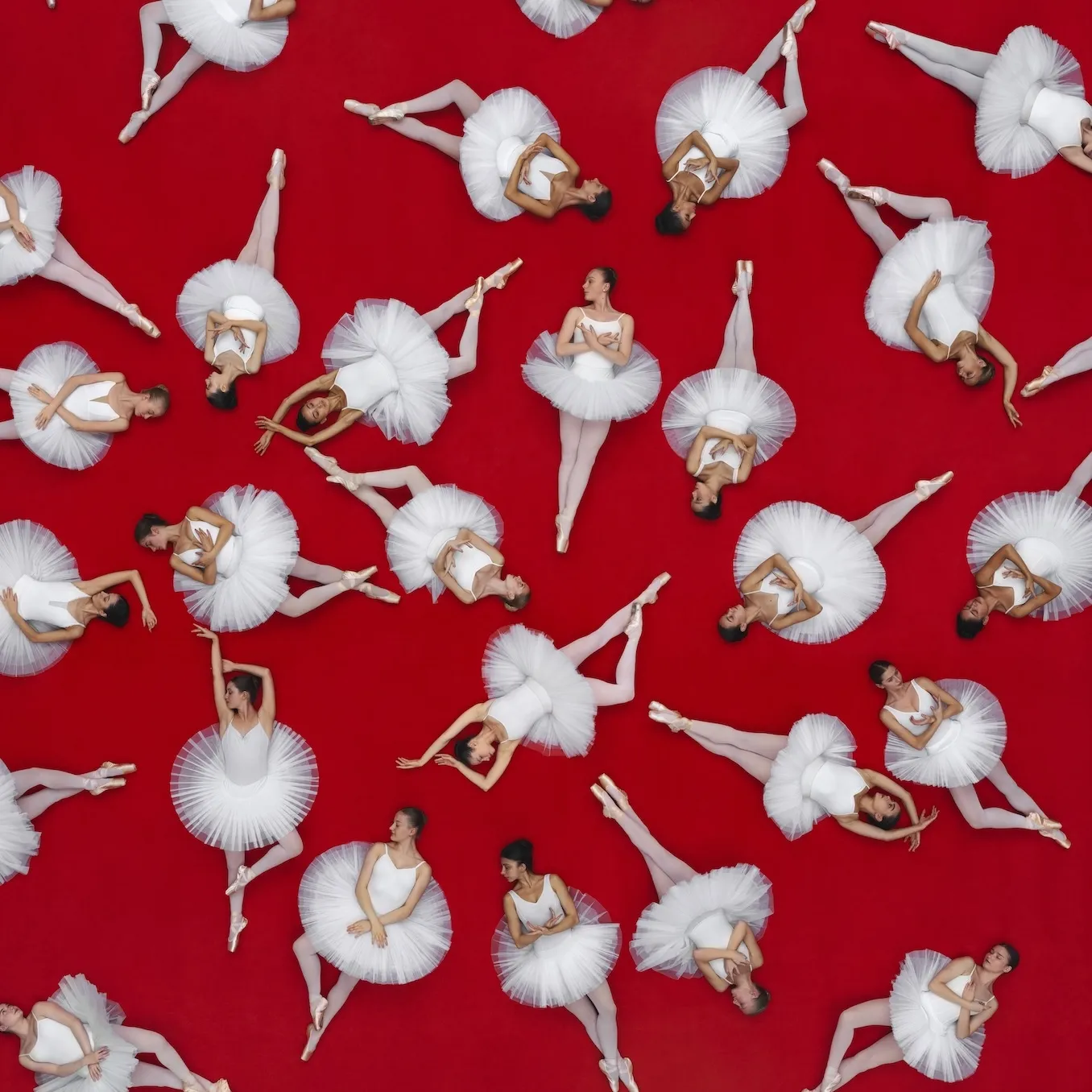 ballerinas in white lying on the floor in different positions with a red background