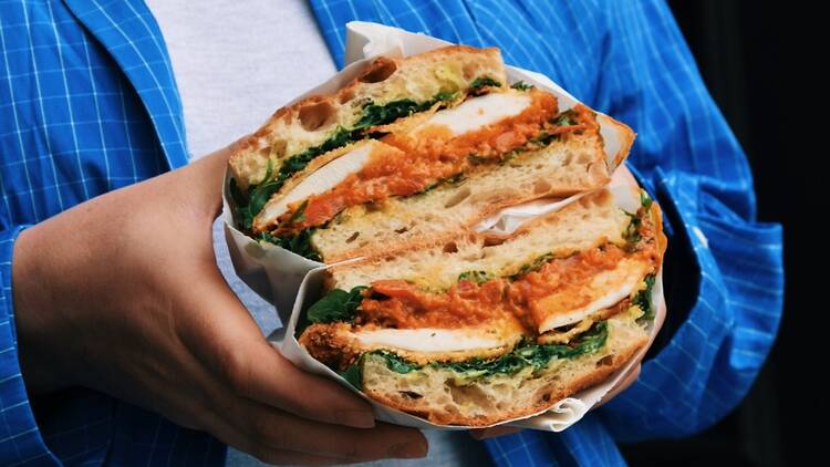 Close-up of somebody holding a large focaccia sandwich from Gladwell’s Deli