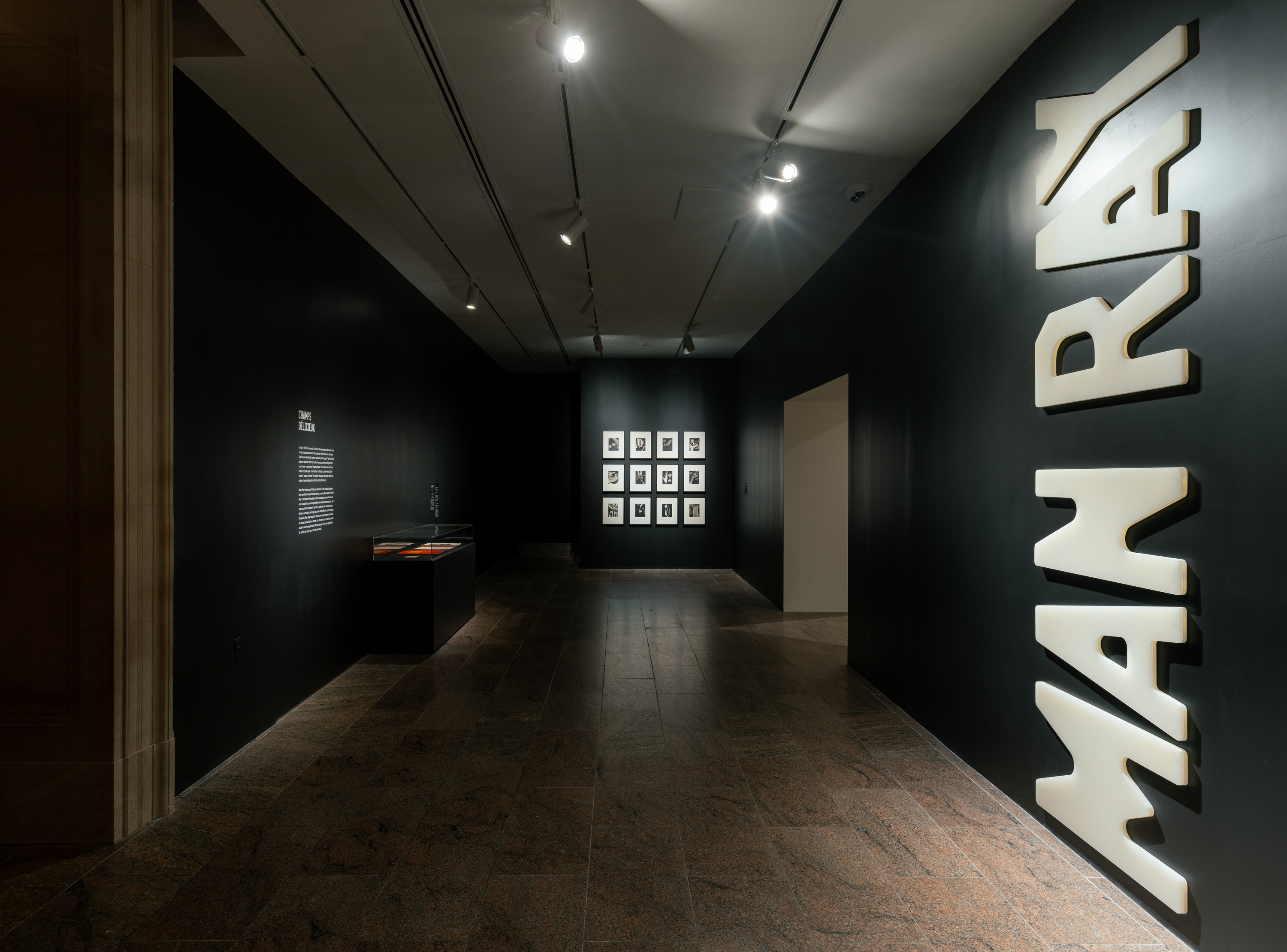 Photographs on a black wall at a museum exhibit.