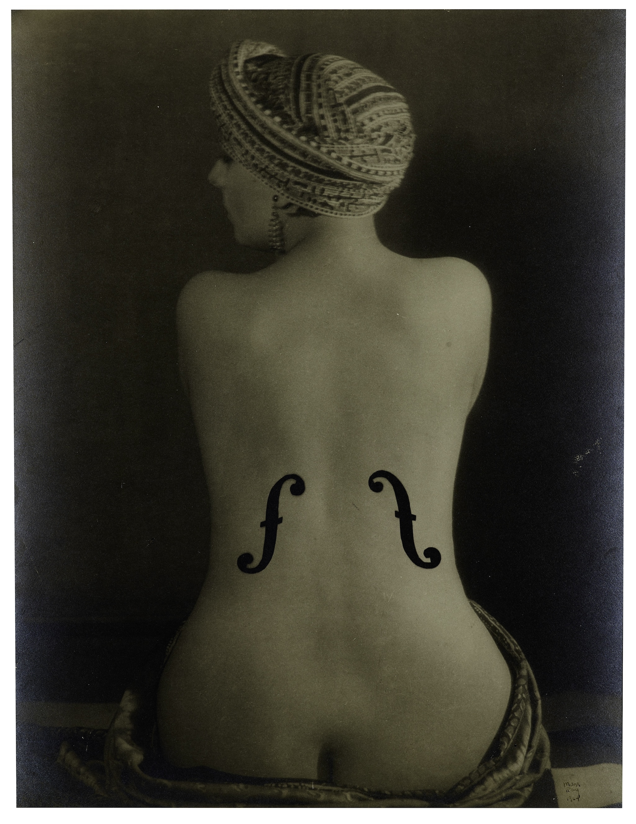 The naked back of a woman with musical insignia on it.
