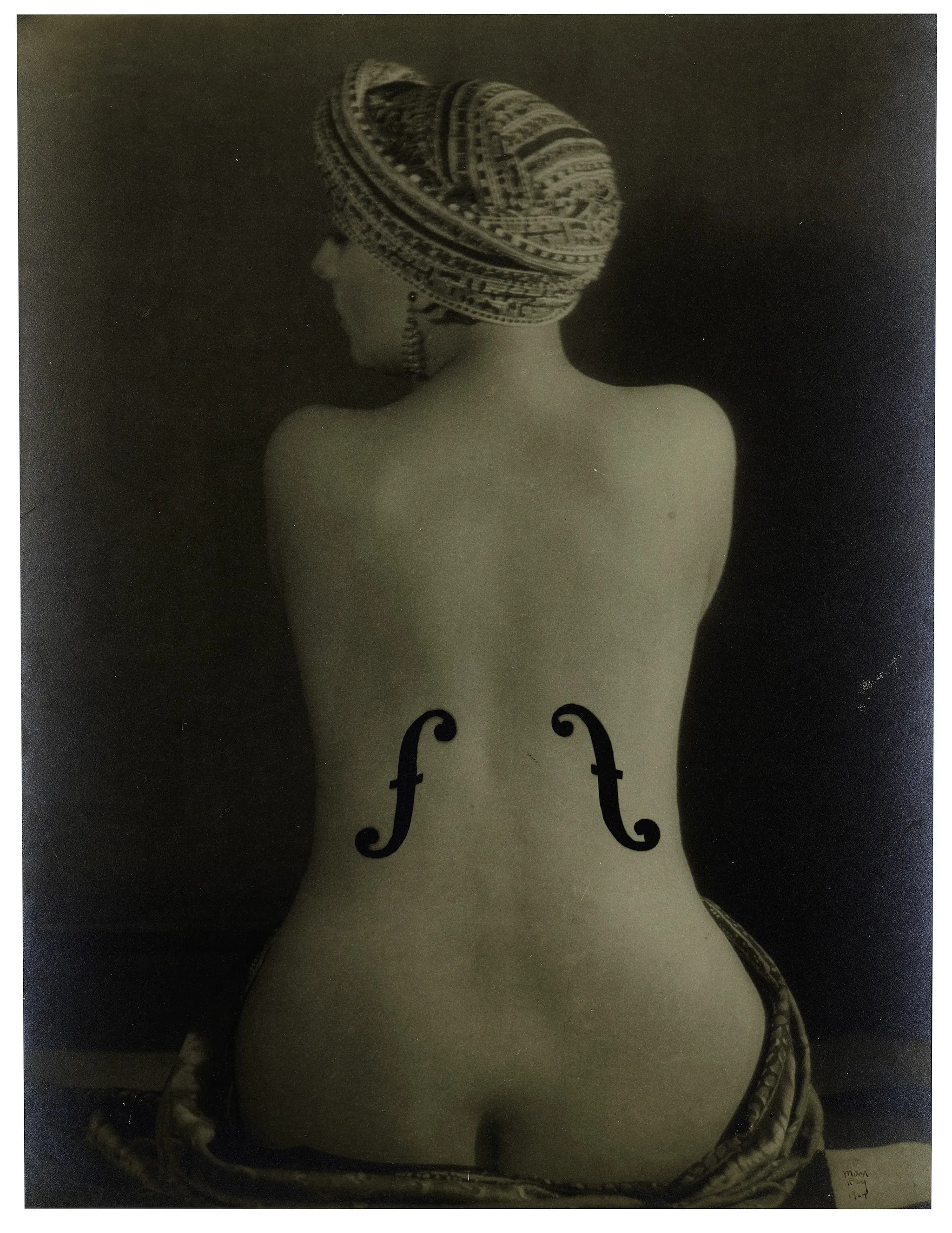 The naked back of a woman with musical insignia on it.