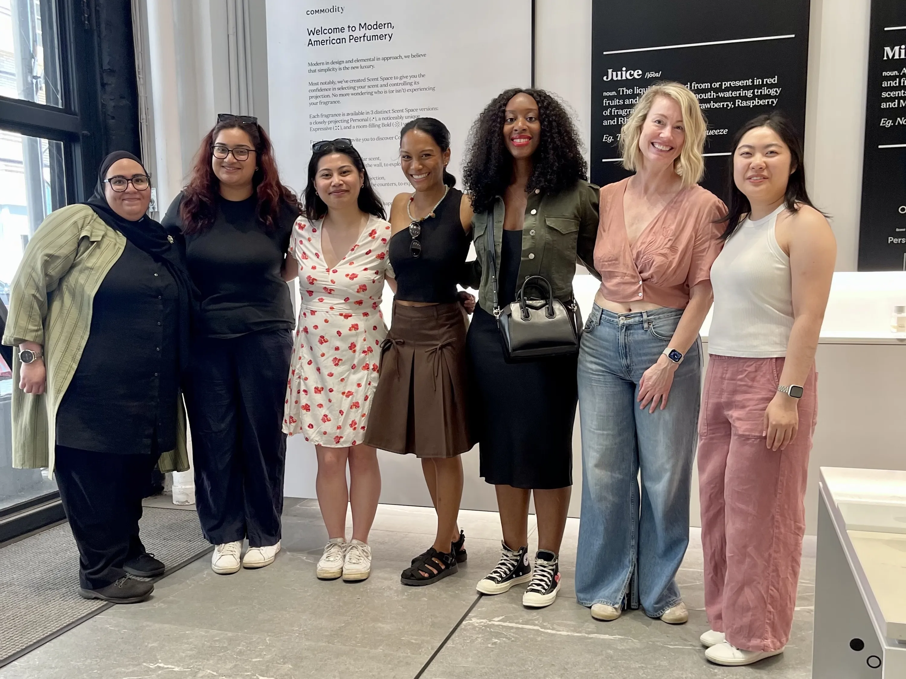 A group of women standing together for a picture in a perfume store