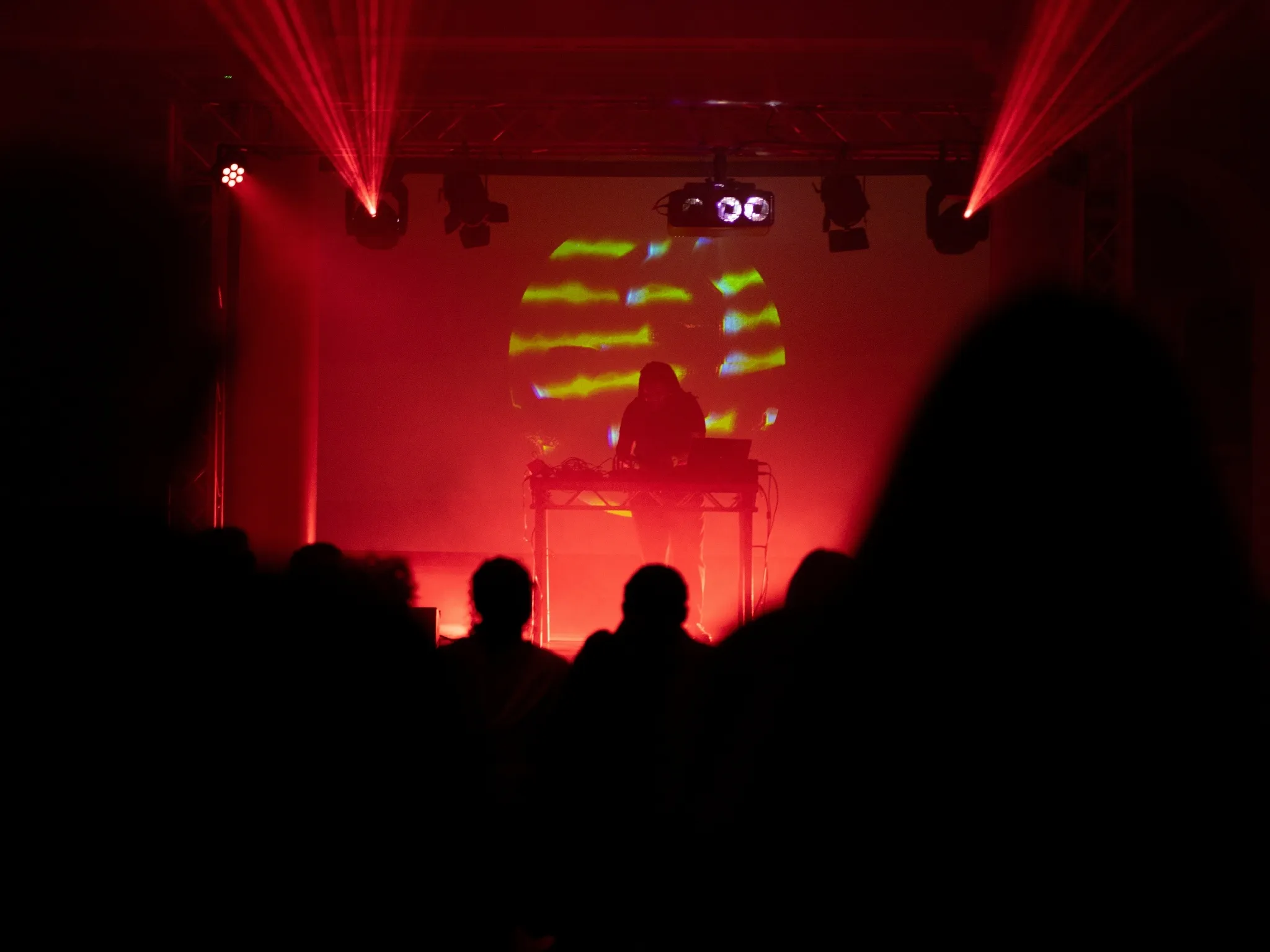 A musician performing on stage in low red lighting at Assembly at Somerset House Studios