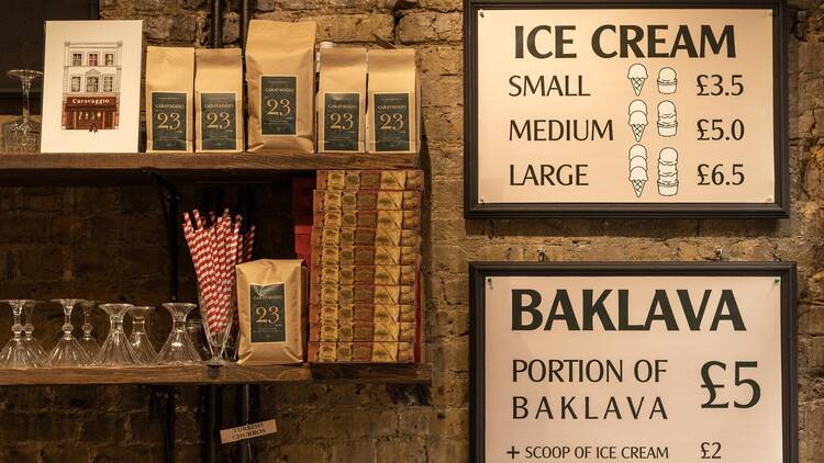 A sign showing the prices against an exposed brick wall at Caravaggio Gelato in Camberwell