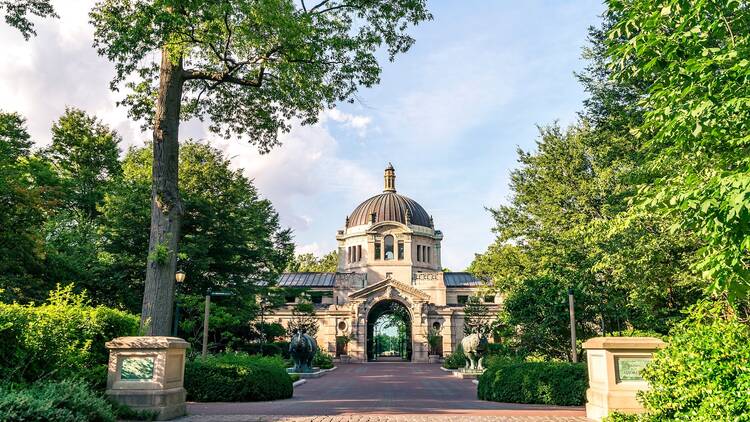 Bronx zoo center entrance with trees in full green.