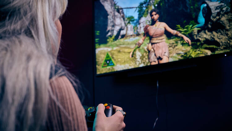 A person with blonde hair playing a video game.