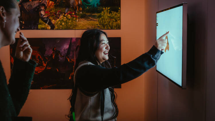 A person pressing a screen at ACMI.