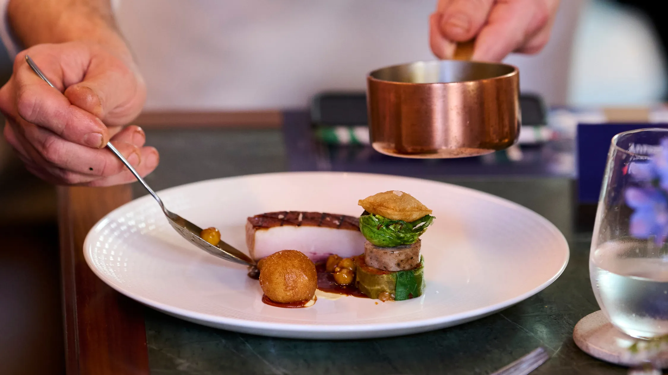 Chef plating dish on white plate