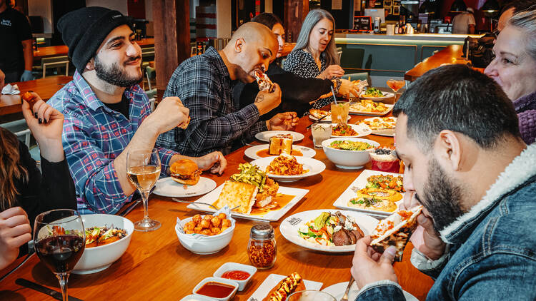 A group of people enjoying drinks and dinner at Time Out Market New York