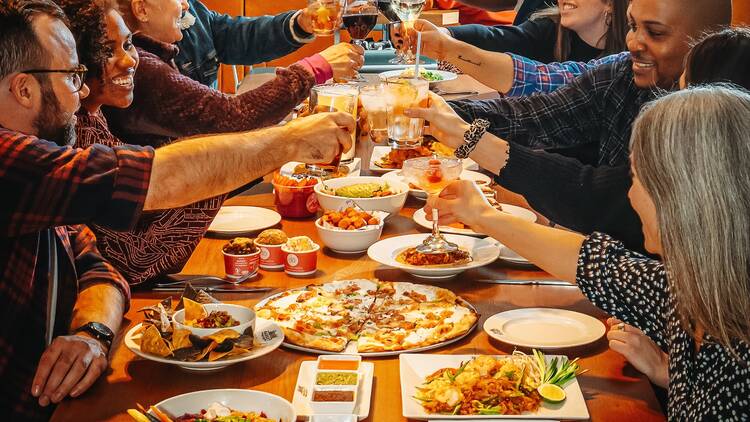 A table full of plates of food at Time Out Market New York