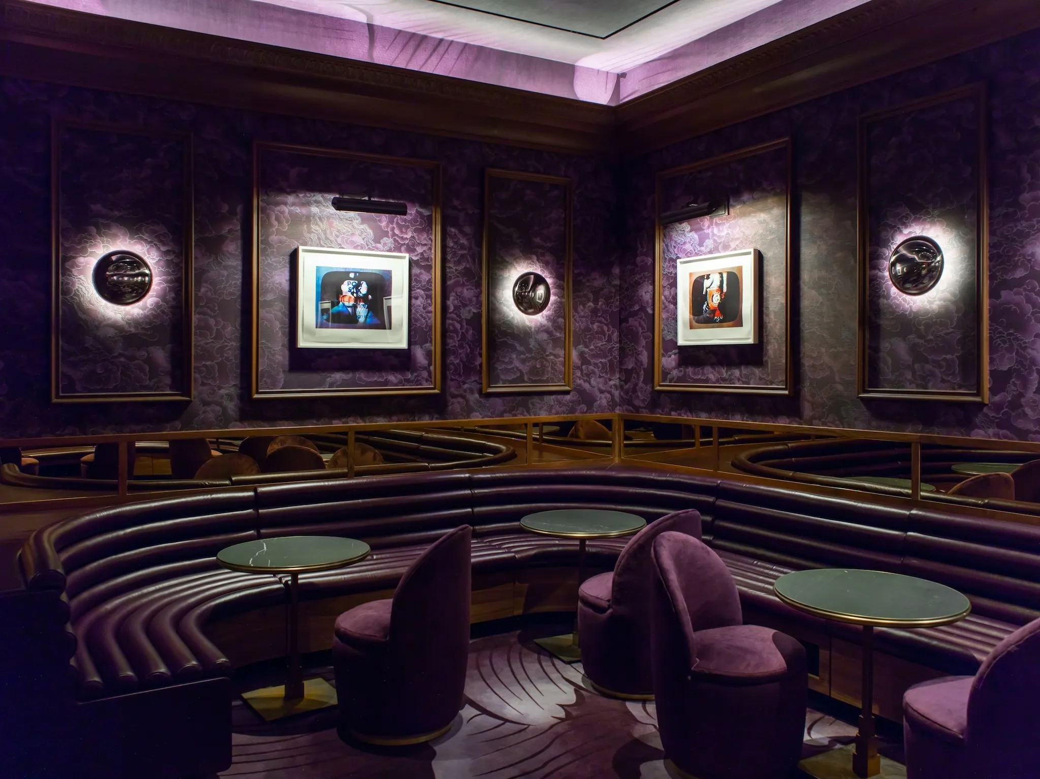 | The basement speakeasy leans on a color palette of purple with leather banquetes, velvet chairs and purple walls and flooring.