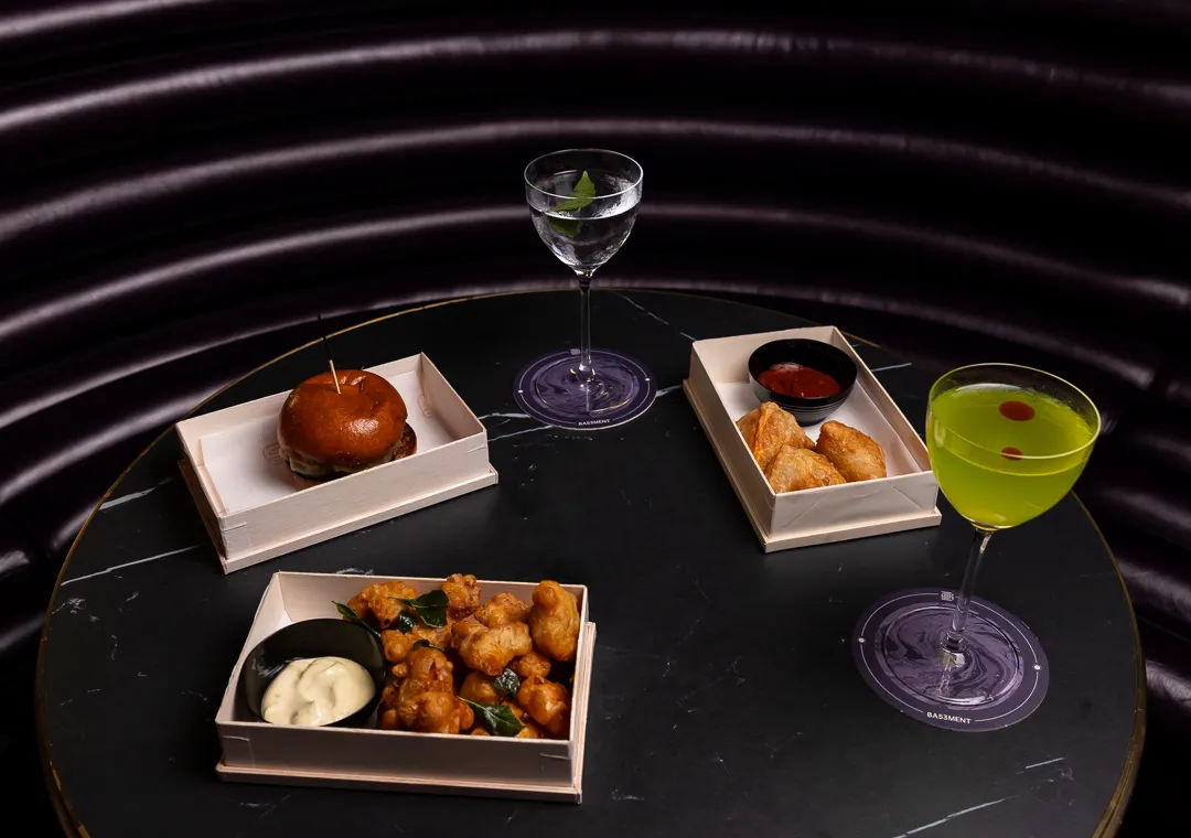 A table with three dishes and two martinis