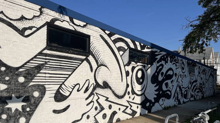 A black-and-white mural painted by Mac Blackout on the east wall of Sleeping Village.