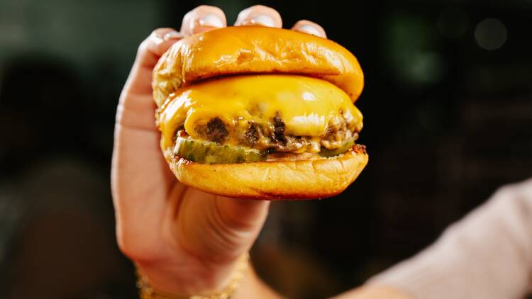 A person holding a burger