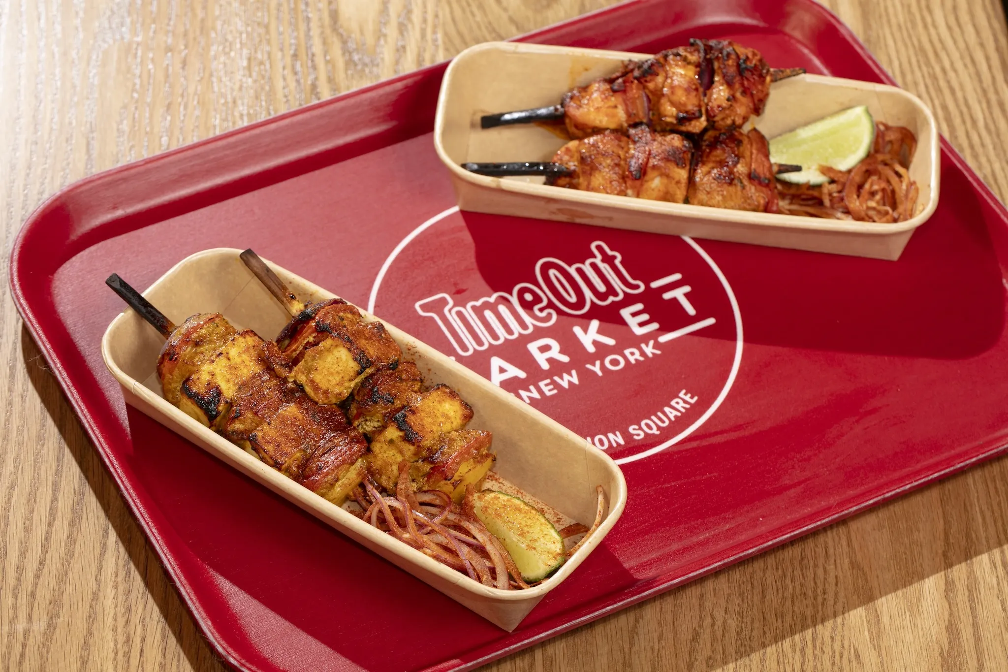 Two kebabs on a red tray that reads Time Out