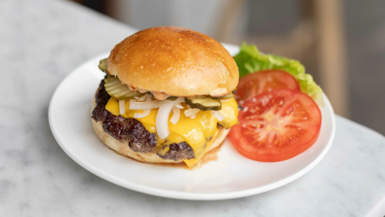 Cheeseburger with tomato and lettuce on plate