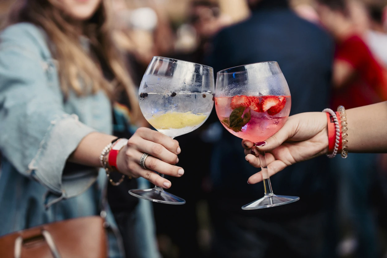 Two women holding a gin and tonic at a festival