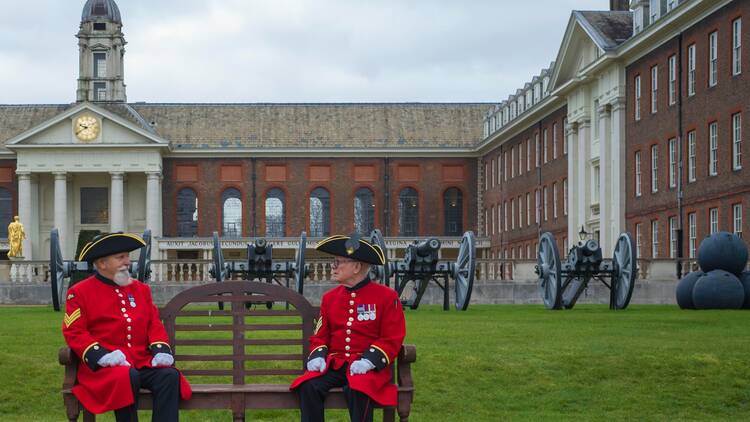 Two Chelsea Pensioners sitting on a bench outside the Royal Hospital Chelsea