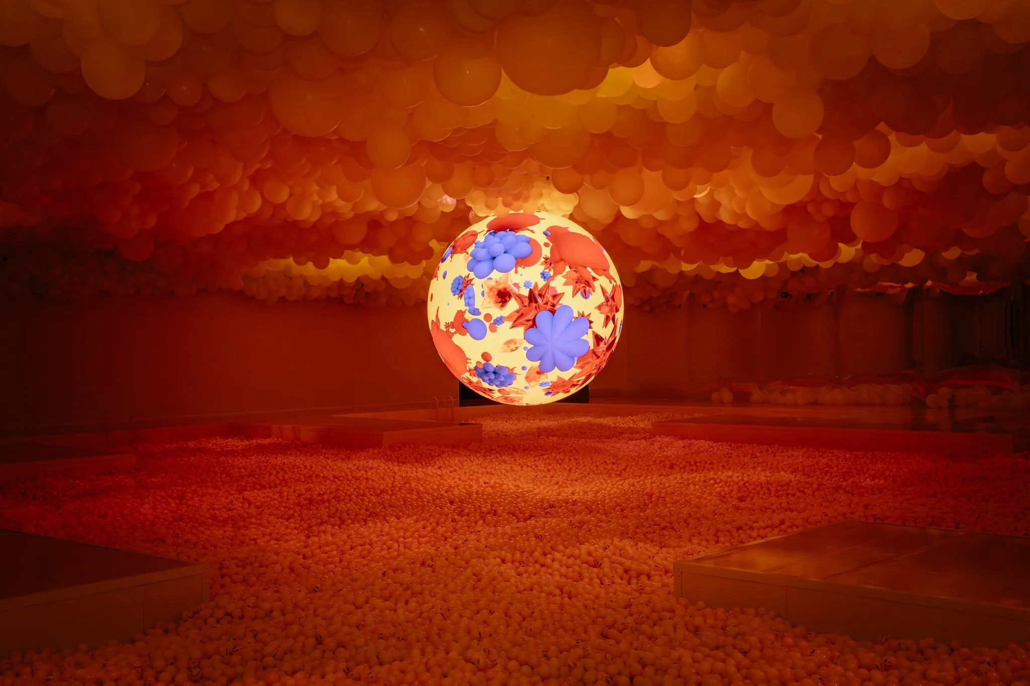 A dramatically lit ball pit surrounding a glowing orb.