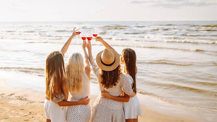 women with drinks on the beach