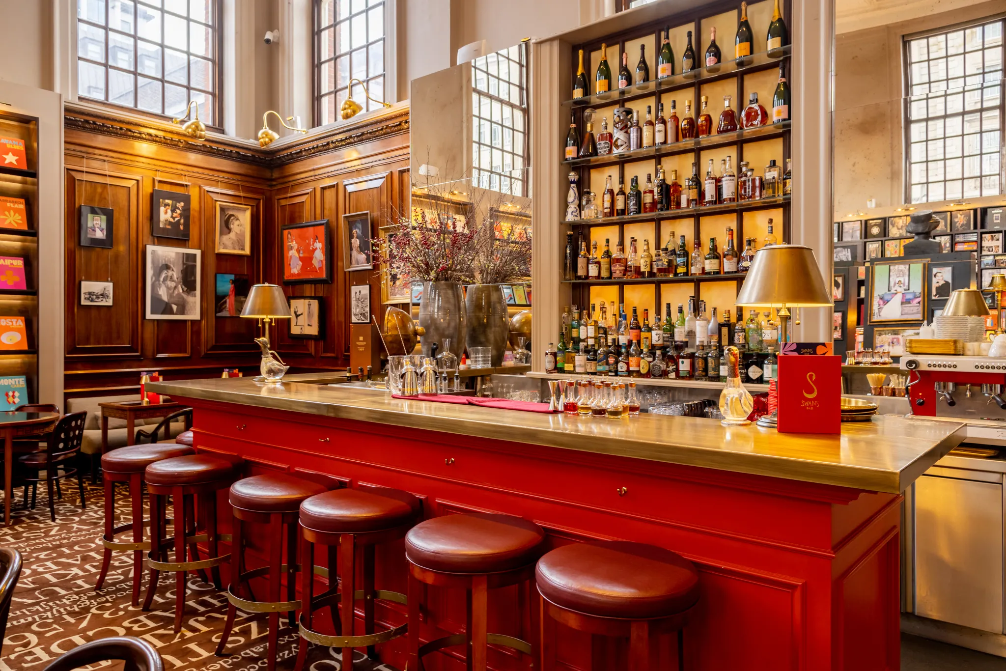 Maison Assouline's red bar lined with bar stools