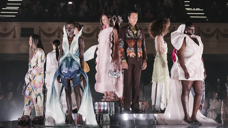 A line-up of models on the runway.