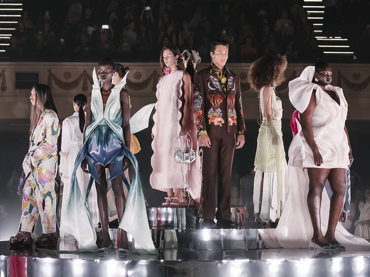 A line-up of models on the runway.