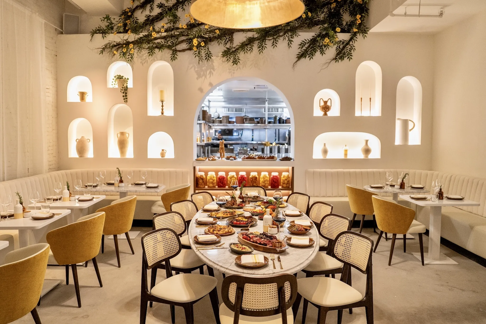 Motek's interior with white walls, yellow chairs and a view inside the kitchen