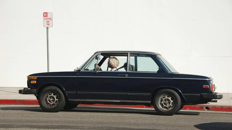 person driving black coupe during daytime