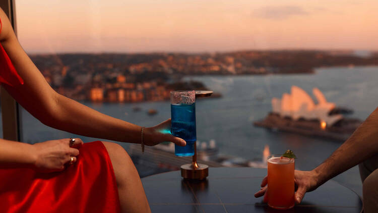 Couple having cocktails with views of Sydney Harbour