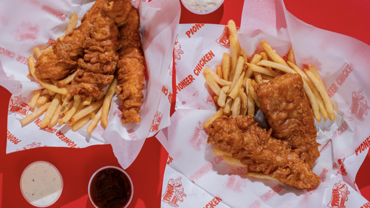 Two baskets of Pioneer Chicken and fries.