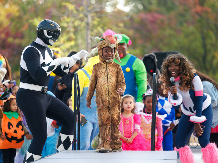 A young boy in a Halloween costume walks on a runway.