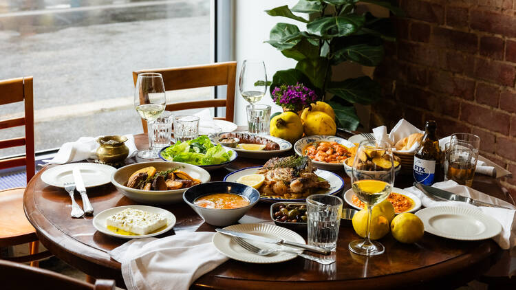 A table laden with Greek food.