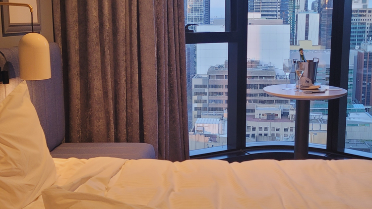 A hotel bed with a city view