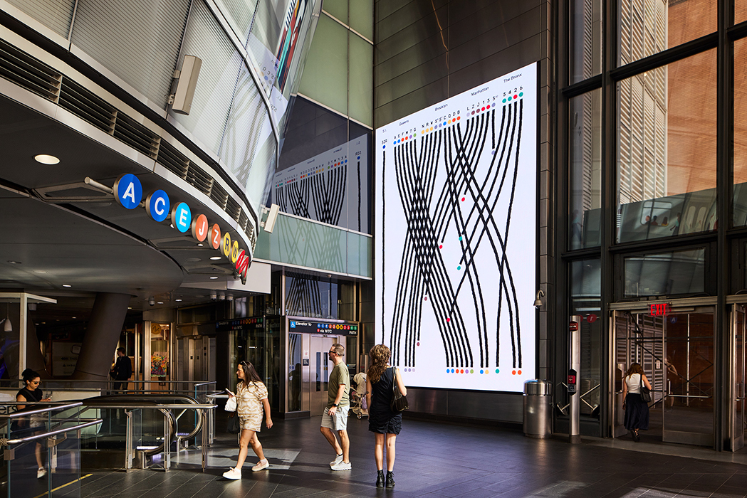 People walk by a digital illustration inside Fulton Center.