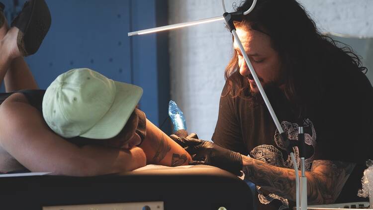 David Allen tattoos a client. David Allen tattoos a client.