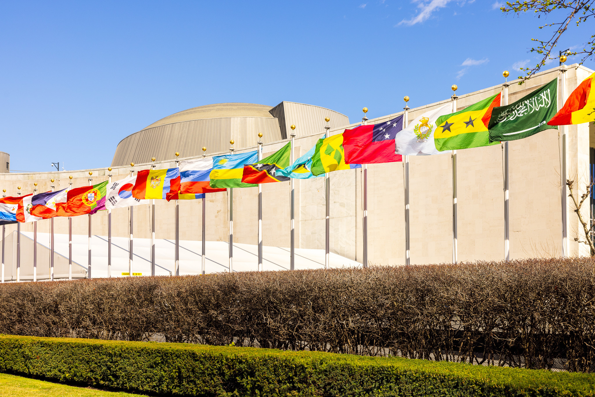 Colorful flags wave outside of the United Nations headquarters in NYC.