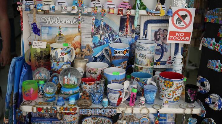 Vibrant display of souvenirs including mugs, keychains, and snow globes in Benidorm